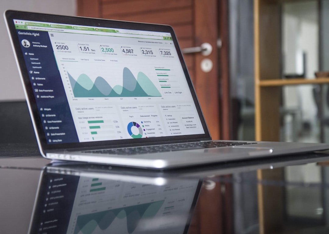 A laptop showing website analytics beside a notebook and phone.